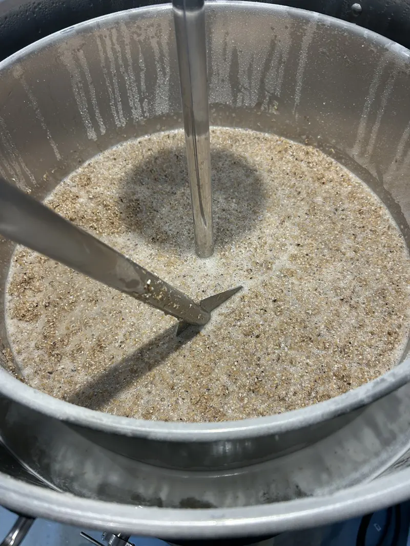 Le grain concassé baigne dans l'eau chaude, brassé à la pagaie.